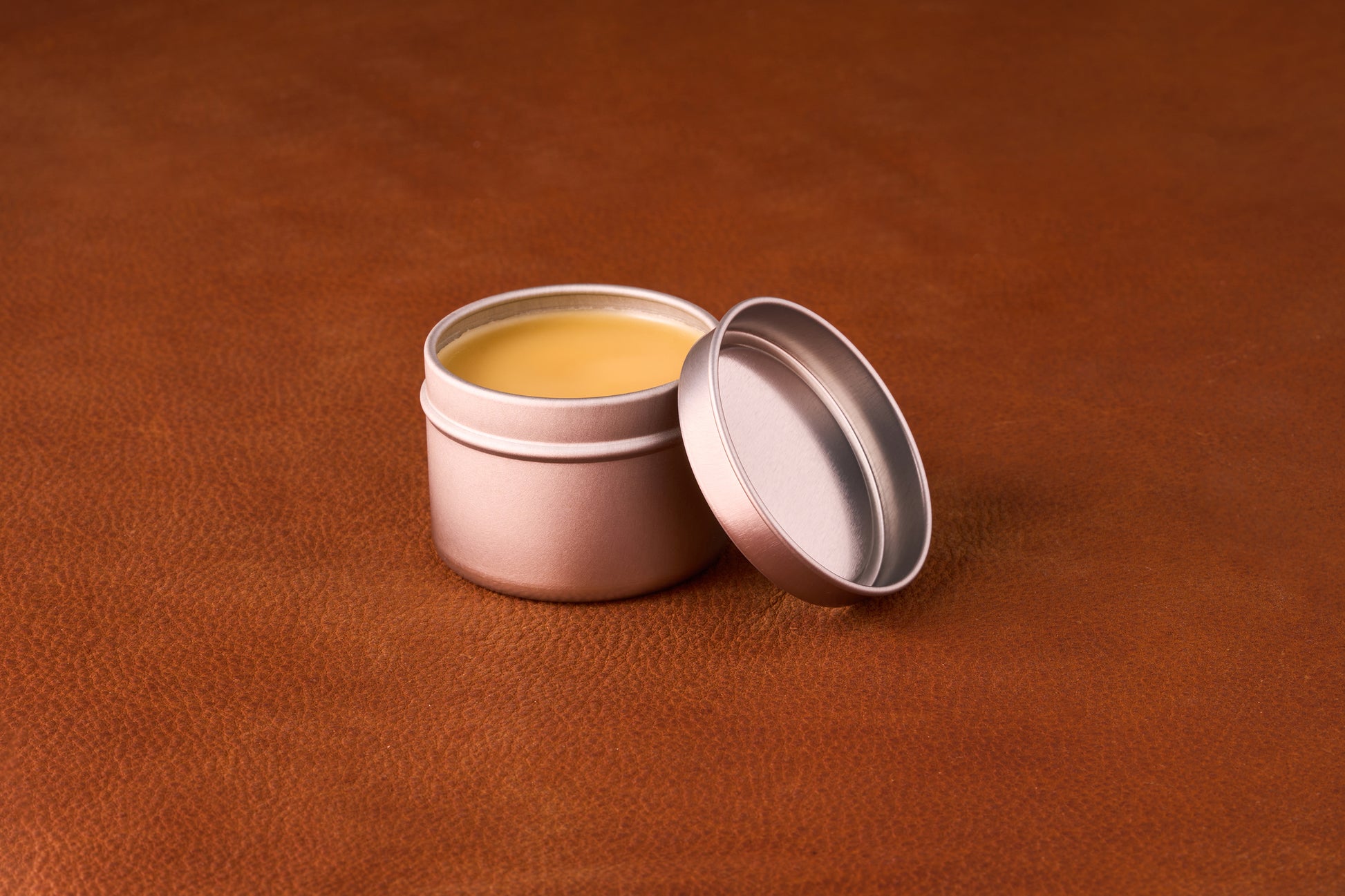 Mammoth Beard Co. Strong Hold Beard Balm Sex & Cigars 60ml tin open on leather surface, showcasing smooth balm for styling and moisturizing beards.