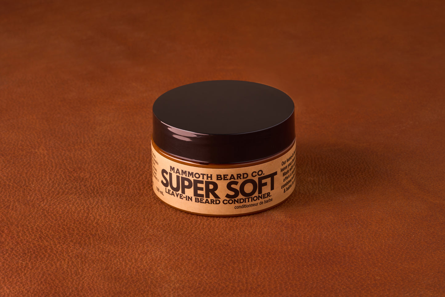 Mammoth Beard Co. Super Soft Leave-In Beard Conditioner Cream Unscented 100ml jar on leather surface, emphasizing natural, hydrating ingredients for any beard length.