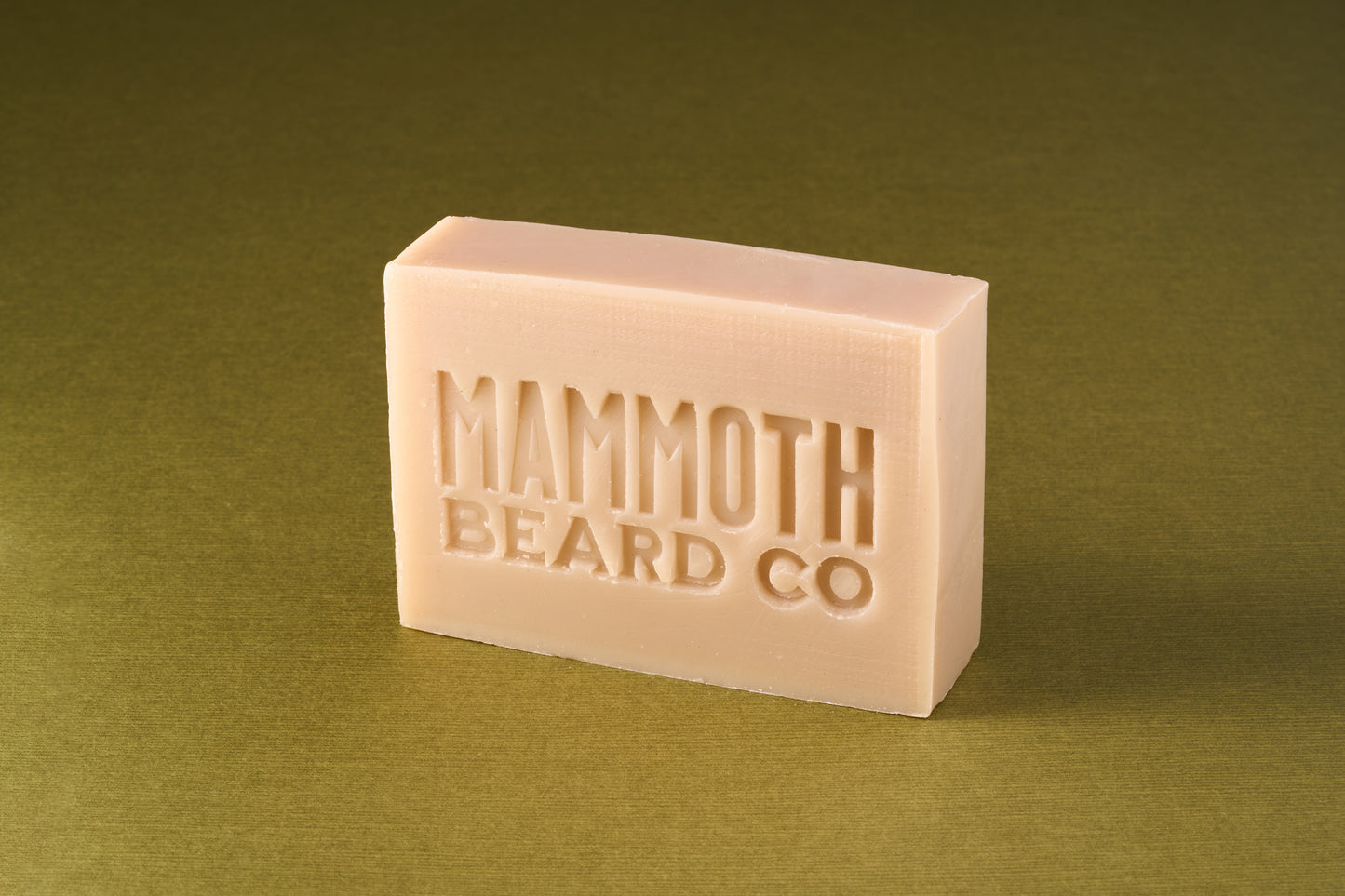 Mammoth Beard Co. Original Cedarwood Beard Soap, a gentle grooming product embossed with the brand name, ideal for holistic beard and body care.