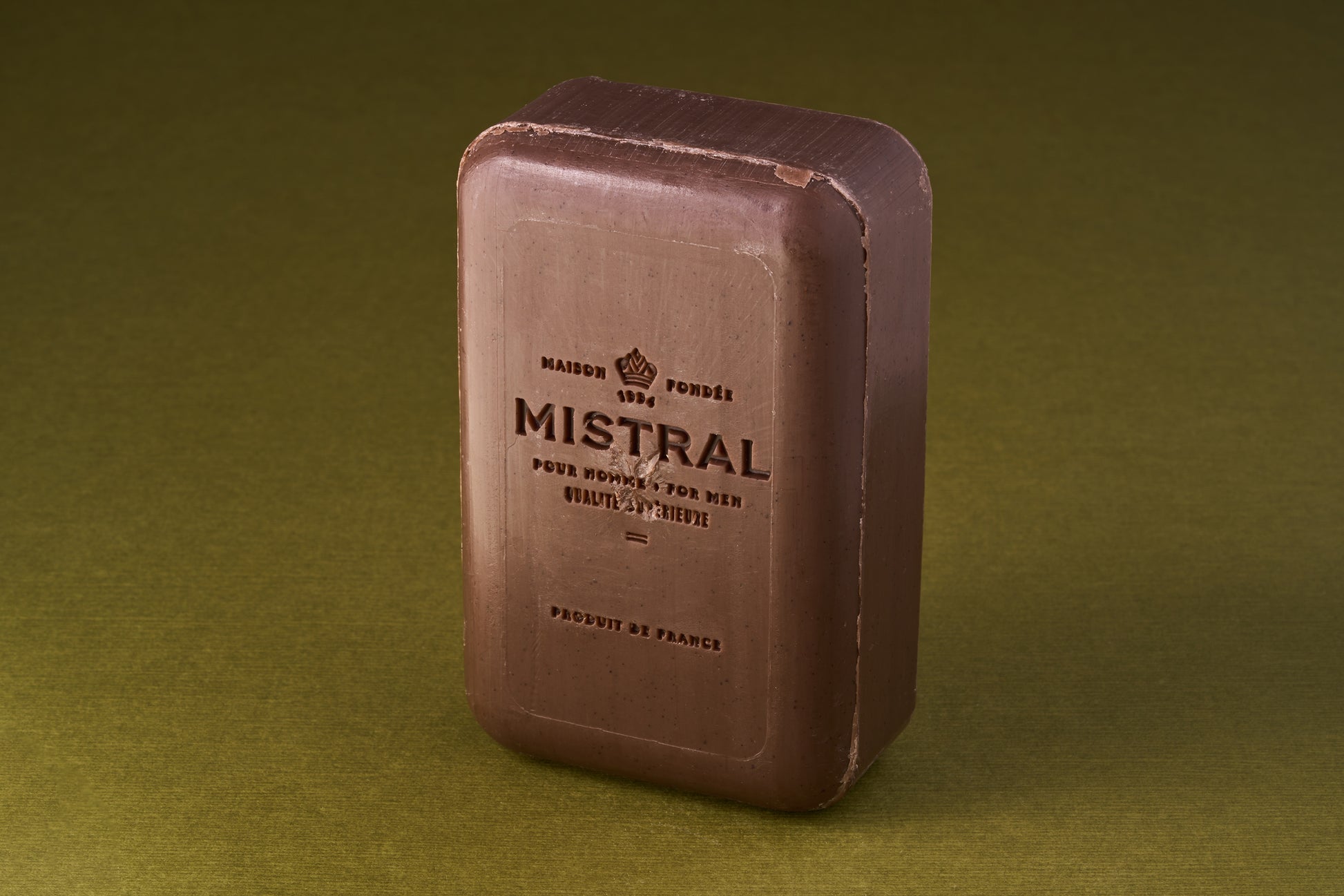 Mistral For Men Bourbon Vanilla Bar Soap, embossed with MISTRAL and French text, offers a luxurious, long-lasting fragrance, perfect for a refined grooming experience.