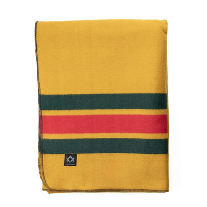 Arcturus Rainier Wool Blanket, mustard-yellow with green and red stripes, folded and durable for outdoor use, ideal for camping and emergency kits.