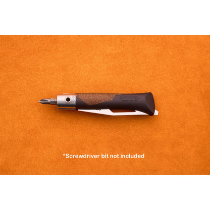 An Opinel Neo 7 Alpine with a black and brown handle and a metal collar is displayed on an orange surface, evoking the classic Opinel style. Text below states, *Screwdriver bit not included.*.
