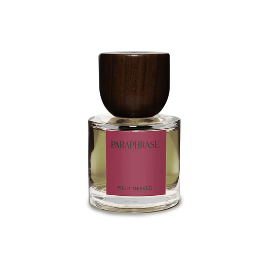 Perfume bottle with wooden cap and pink label on a white background