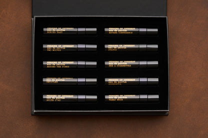 The Persons of Interest Eau de Parfum Discovery Kit features ten unisex 5ml fragrances, each housed in a sleek black box with gold-labeled vials fitted into individual slots. This curated set includes scents like STRANGE PARADISE, STATIC, SEX + CIGARETTES, and more.