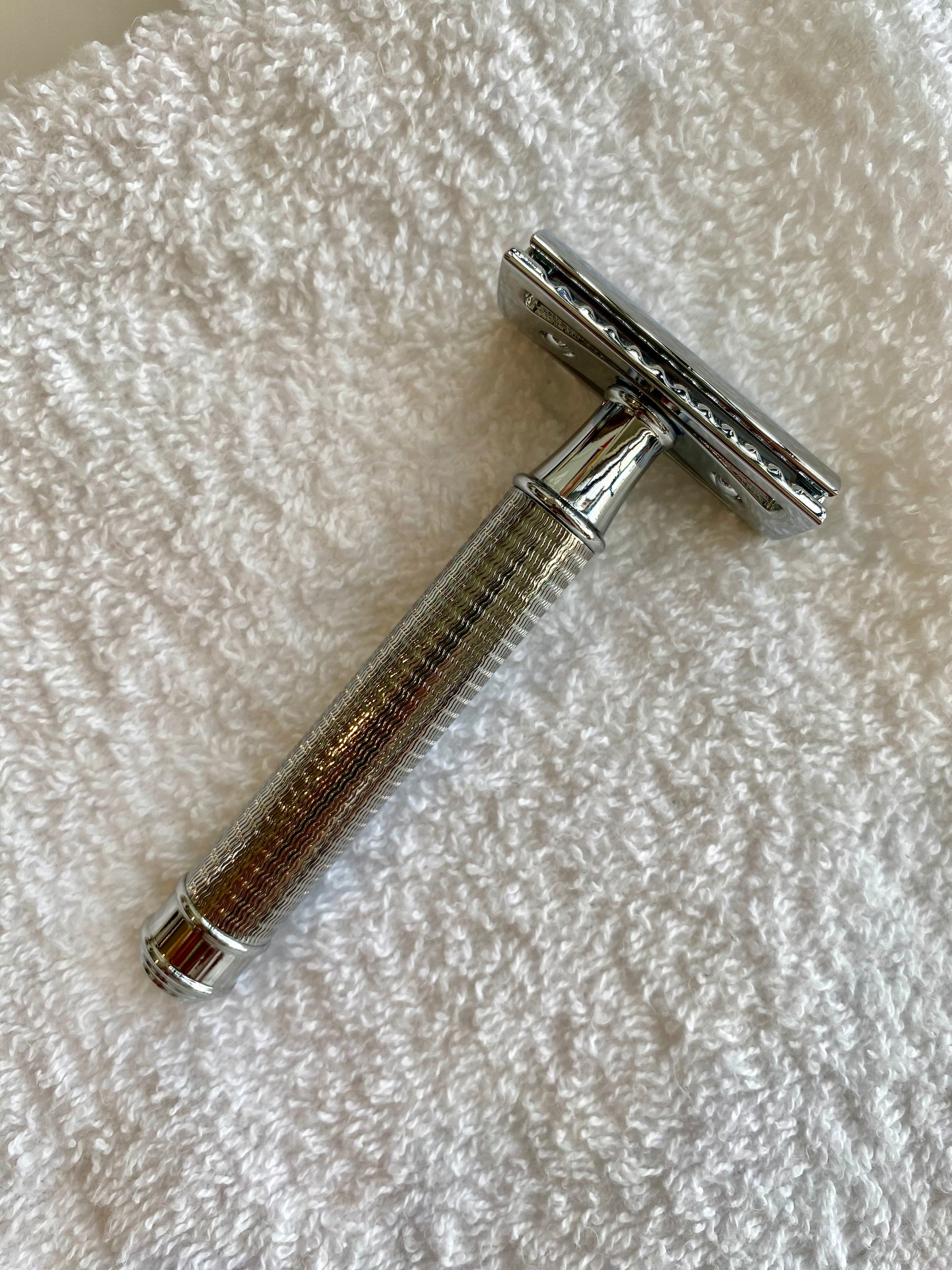 Nolan's All-In-One Shaving Kit, featuring a double-edge safety razor with knurled handle, elegantly positioned on a towel, epitomizing classic shaving craftsmanship.