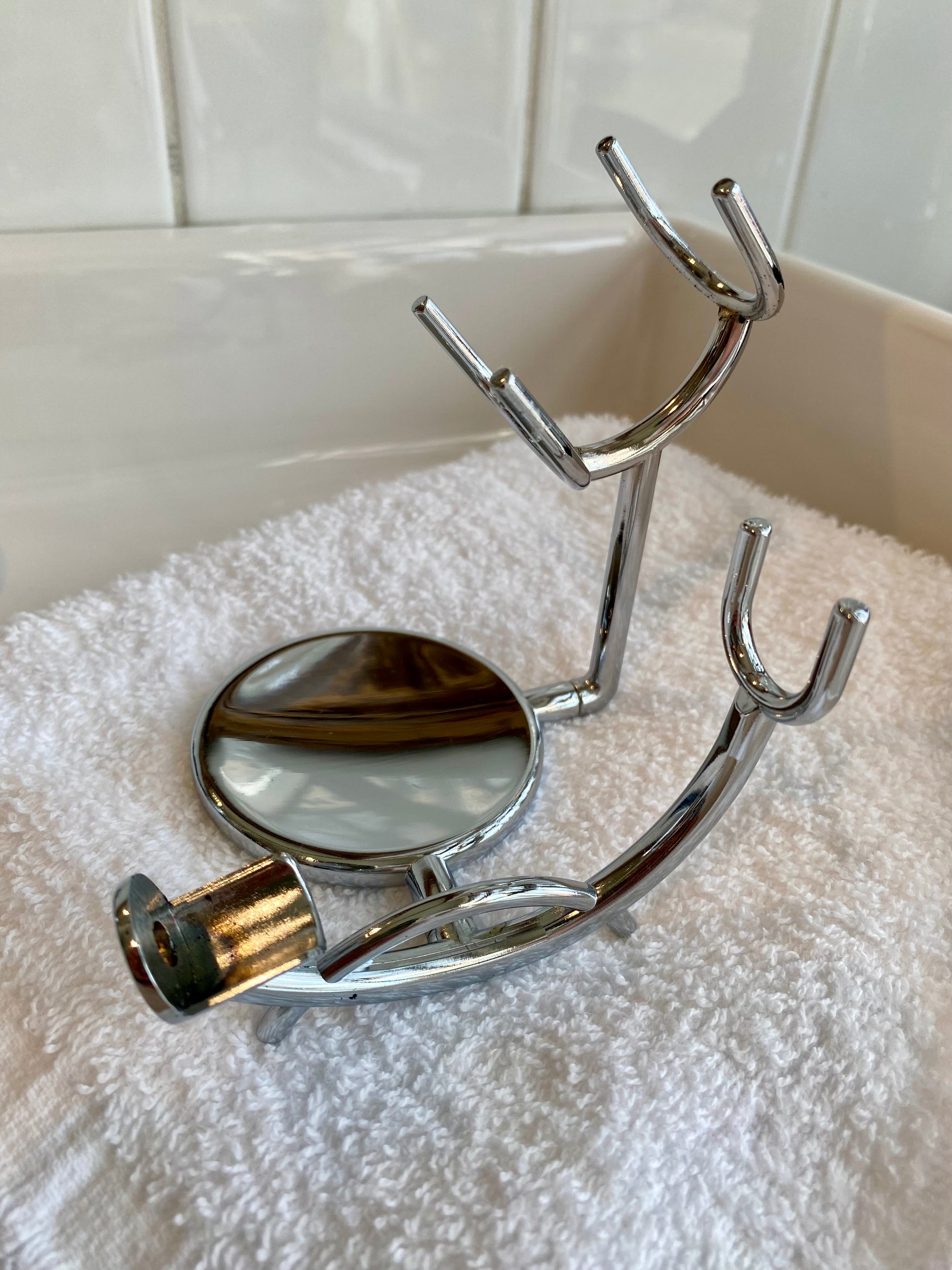 Nolan's All-In-One Shaving Kit featuring a chrome rack for holding a shaving brush and safety razor, displayed on a white towel.