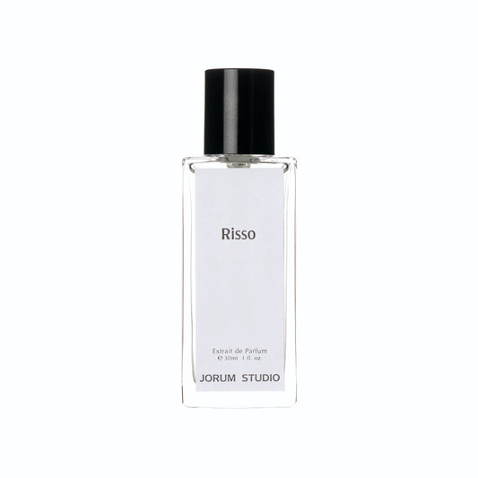 A clear glass perfume bottle with a black cap, featuring a label inscribed with “Risso,” “Extrait de Parfum,” and “JORUM STUDIO.” This elegant 30ml (1 fl. oz) bottle contains the Jorum Studio Risso ExDP fragrance—a sophisticated luxury scent from the independent fragrance house, Jorum Studio.