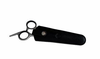 Rockwell Hair and Beard Scissors partially tucked in a black leather scissor-holster, designed for precise trimming without pulling, suitable for personal or professional use.