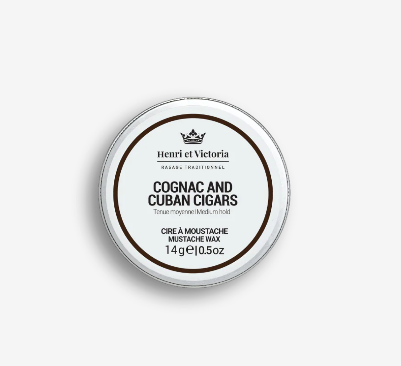 Henri et Victoria Cognac and Cuban Cigars Moustache Wax in a round tin, offering medium hold with a cedarwood, leather, lemon, cognac, and tobacco scent.