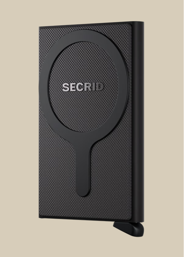 A black textured Secrid Wallets Cardprotector for MagSafe, featuring a circular and straight-line design with RFID blocking, stands upright against a plain beige background.