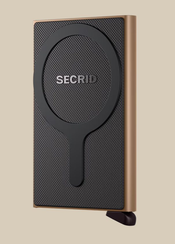The Secrid Wallets Cardprotector for MagSafe is a slim, rectangular wallet with a textured black front, circular grip design, metallic bronze edges, and RFID blocking, shown standing upright against a beige background.