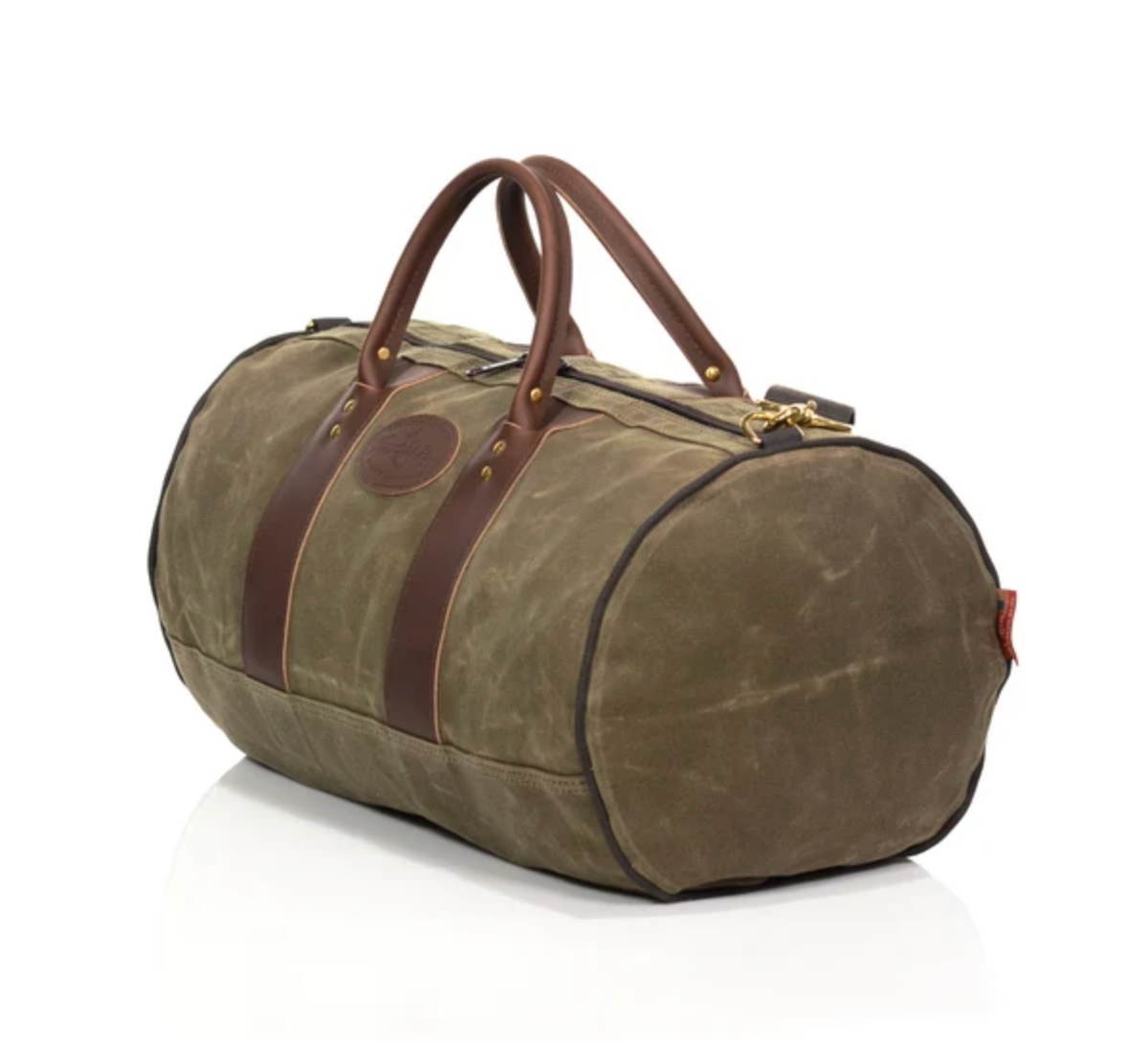 Introducing the Frost River ImOut Carry On—a durable travel bag crafted from green waxed canvas, featuring brown leather handles and accents, a gold zipper, and a small red tag on one end, all set against a white background.