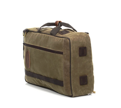 The Frost River Voyageur Backpack, crafted from brown waxed canvas with dark brown accents, features a top handle and a front zipper pocket. Shown at an angle on a white background, this durable backpack draws inspiration from classic Frost River style, blending rugged materials and timeless design for versatile everyday use.