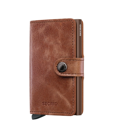Secrid Wallets Miniwallet - Vintage: Distressed brown leather card holder with snap closure, embossed branding, and aluminum card protector featuring a stylish card ejection lever.