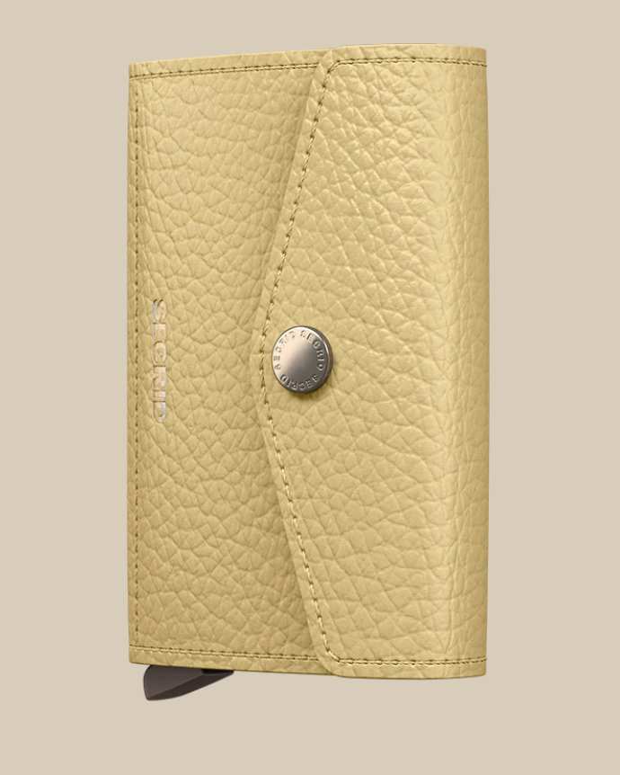 The Secrid Envelope Wallet features tan, textured leather, a snap button closure, embossed SECRID branding, and RFID blocking. It’s showcased against a plain beige background.