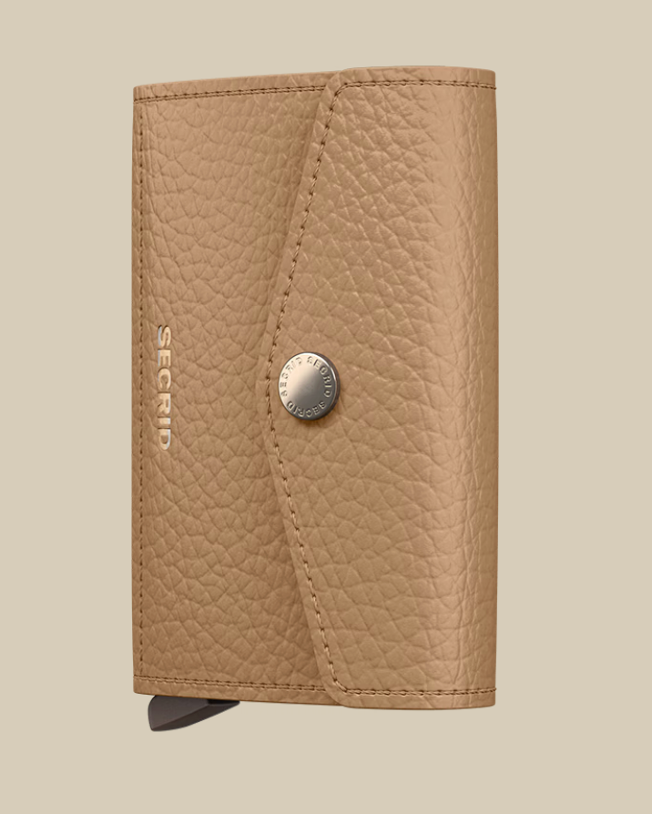 The Secrid Envelope Wallet features a tan textured finish, snap button closure, and SECRID embossed in silver on the front. This RFID-blocking wallet is displayed against a light beige background.