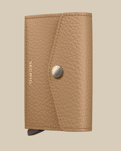 The Secrid Envelope Wallet features a tan textured finish, snap button closure, and SECRID embossed in silver on the front. This RFID-blocking wallet is displayed against a light beige background.
