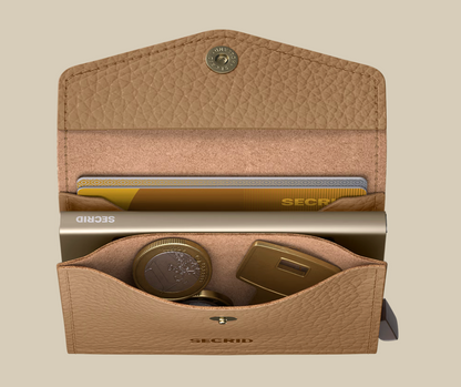 An open Secrid Envelope Wallet in tan leather displays cards, coins, and a gold USB drive neatly inside against a beige background. This wallet offers RFID blocking for secure and stylish organization.