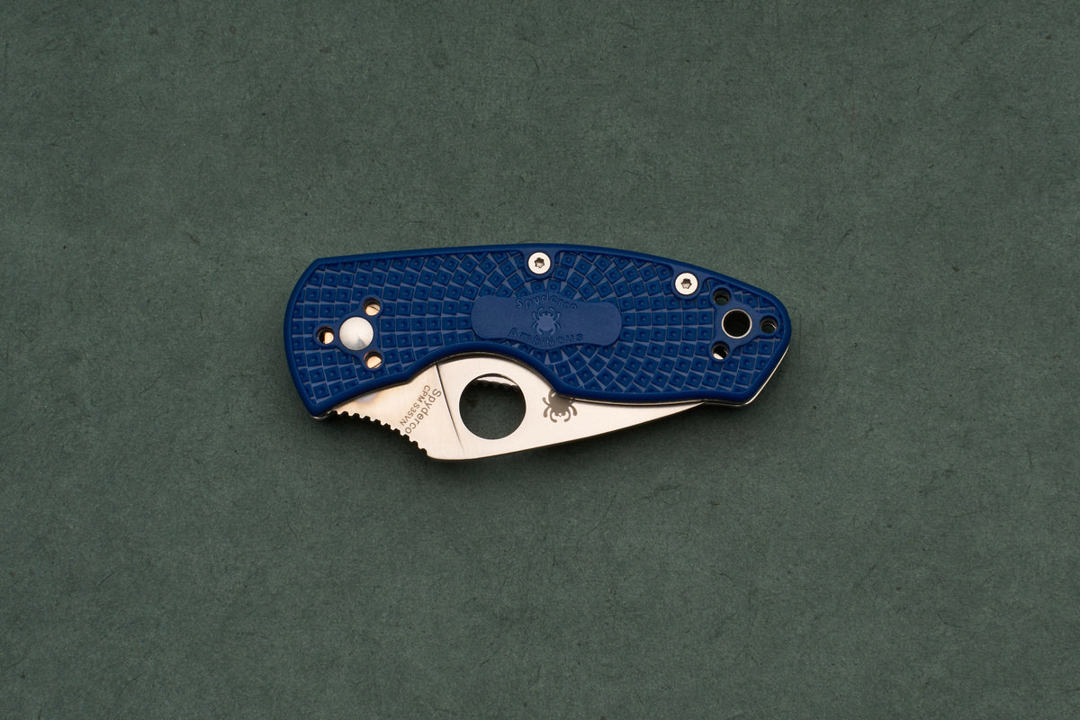 A blue Spyderco Ambitious Blue Lightweight CPM folding pocket knife with a textured handle and a partially extended steel blade designed for one-handed opening.