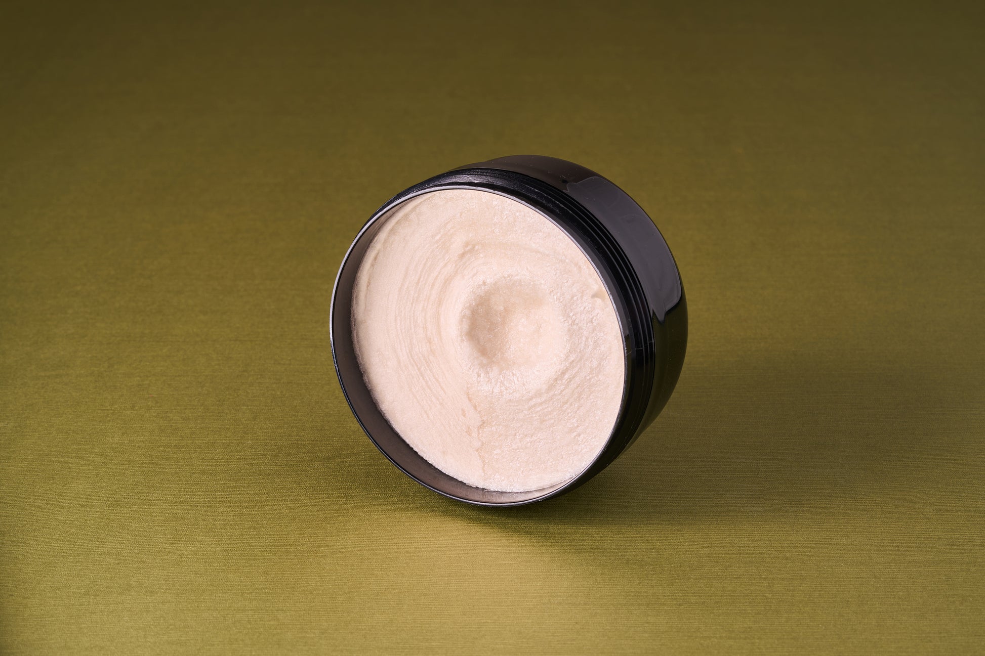 Taylor of Old Bond Street Tobacco Leaf Shaving Cream in an open black jar, showcasing its rich, off-white whipped texture, ideal for a luxurious shaving experience.