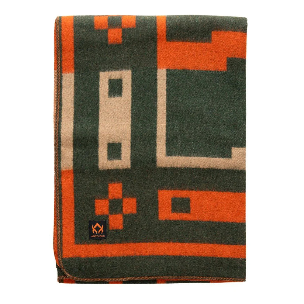 The Arcturus Rainier Wool Blanket is a folded wool blanket featuring a geometric pattern in green, orange, and beige. Ideal for camping or cozy evenings at home, this blanket includes a small rectangular black label with an orange logo sewn onto one corner.