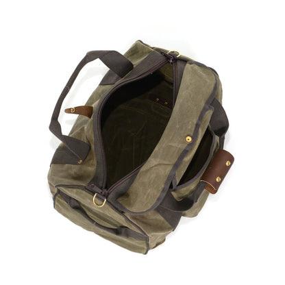 Frost River Explorer Duffel ESB No. 713: Top-down view of an olive-green canvas duffel with leather trim, brass hardware, and versatile backstraps, ideal for travel.