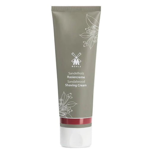 A tube of Mühle Sandalwood Shaving Cream, featuring a gray body, white cap, floral design, and white product details, provides a luxurious natural shaving cream experience.