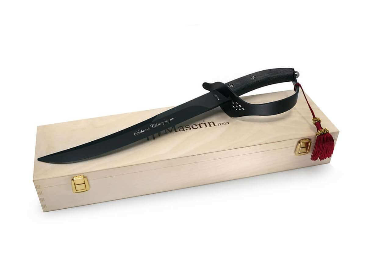 Black knife with leather sheath in a wooden box on a white background