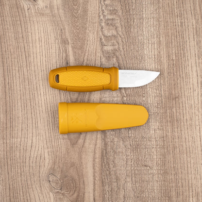 Mora Eldris Fire Kit with yellow handle and sheath on wood surface, includes lanyard, belt loop, and ferro-rod for outdoor enthusiasts.