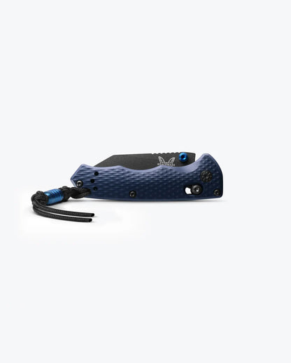 A closed Benchmade Full Immunity folding pocket knife with a blue finish, featuring a black textured grip and a black lanyard attached to the handle, displayed against a plain white background.