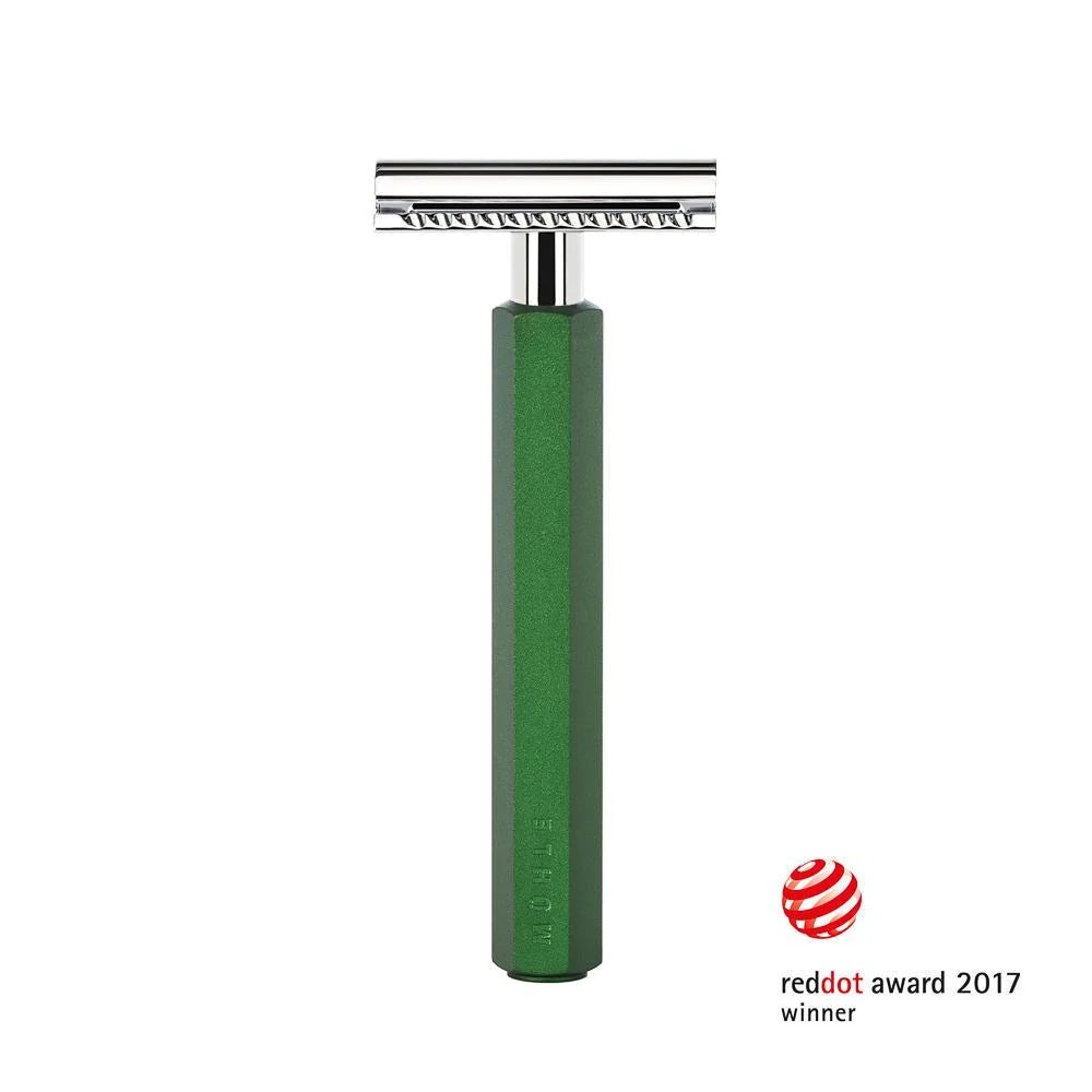 The Mühle Hexagon Safety Razor, showcased upright with its signature green anodised aluminum handle and sleek silver head, exemplifies modern shave culture. The bottom right features the red dot design award logo and the text “reddot award 2017 winner,” highlighting its acclaimed design.
