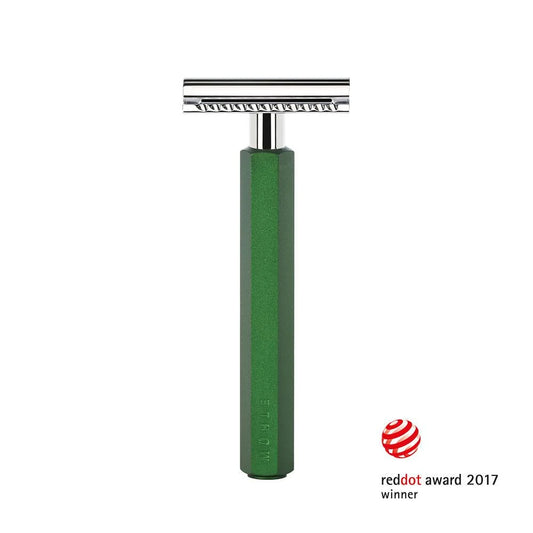 The Mühle Hexagon Safety Razor, showcased upright with its signature green anodised aluminum handle and sleek silver head, exemplifies modern shave culture. The bottom right features the red dot design award logo and the text “reddot award 2017 winner,” highlighting its acclaimed design.
