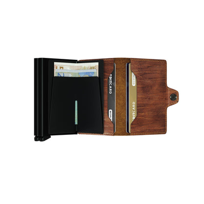 Secrid Wallets Twinwallet features a brown leather bifold design with card slots, an RFID-blocking compartment, and a lever for easy card access.