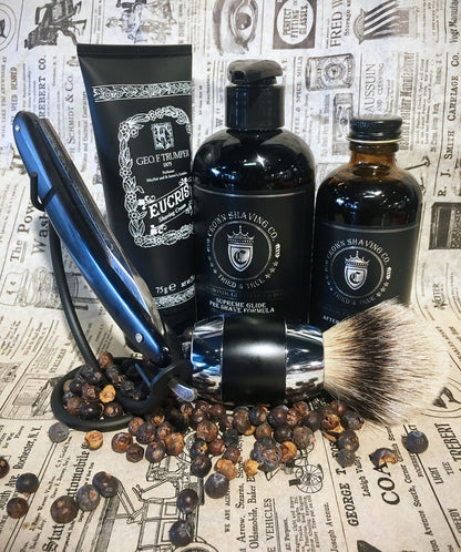 Curved Stand for Straight Razors displayed in a classic shaving setup with a straight razor, brush, shaving cream, pre-shave, aftershave, and juniper berries.
