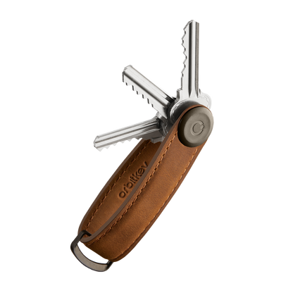 Orbitkey Crazy Horse Leather Key Organizer with brown leather sleeve, holding several metal keys fanned out, featuring a D-ring for attaching large keys.