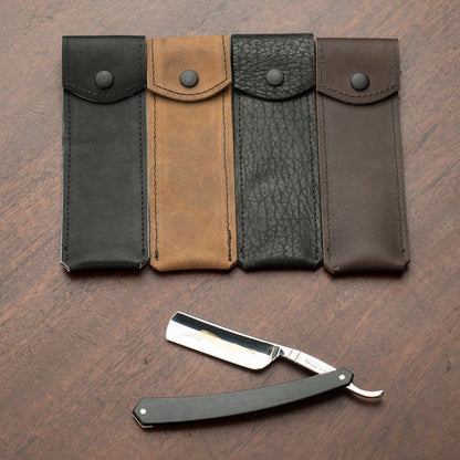 Horace & Jasper Leather Straight Razor Case in four leather styles for safe razor storage, displayed open on a wooden surface. Razor not included.