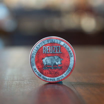 Reuzel Pomade Regular Red tin on wood surface, offering medium hold and high shine for all hair lengths, perfect for classic, shiny styles.