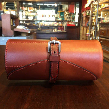 Odegard Seven Straight Razor Roll: Reddish-brown leather case with contrast stitching, secured by a strap and buckle, crafted by Arlen and Cynthia Odegard in Alberta.
