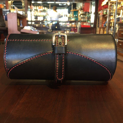 Odegard Seven Straight Razor Roll in smooth leather with red stitching, secured by a strap and buckle, handcrafted for quality and durability.