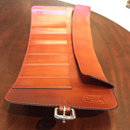 Odegard Seven Straight Razor Roll, a handcrafted leather roll-up pouch with stitched slots for organizing razors, laid flat on a wooden tabletop.