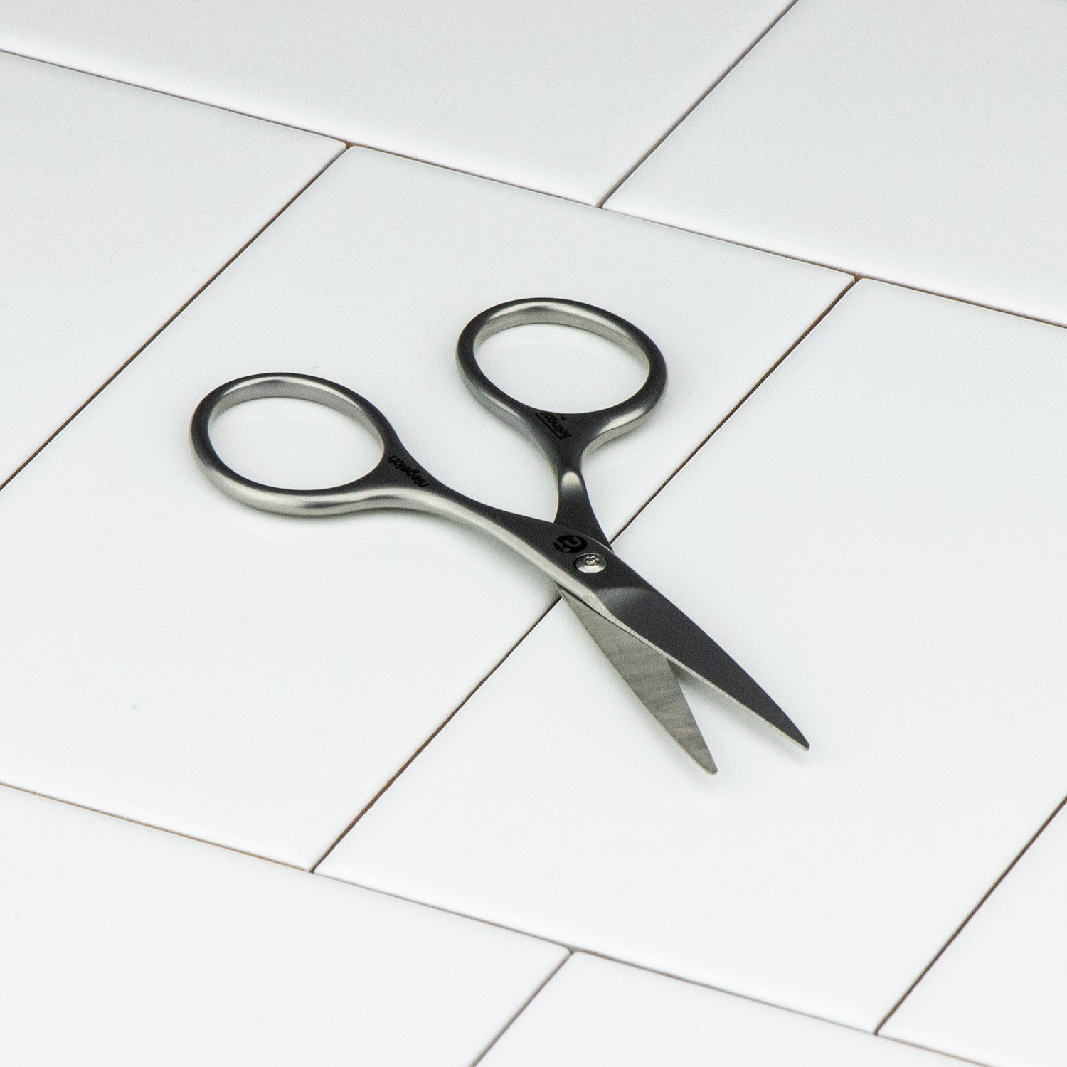 Niegeloh Moustache Scissor, stainless steel with large grips for precision, made in Solingen, Germany, on a white tile surface.