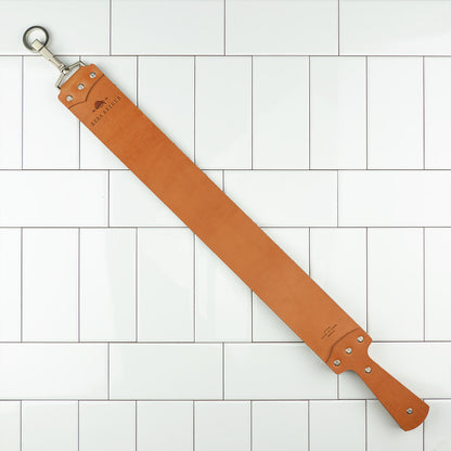 Ezra Arthur English Bridle Strop, a two-sided tan leather honing strap with handle and hanging ring, ideal for refining straight razor edges.