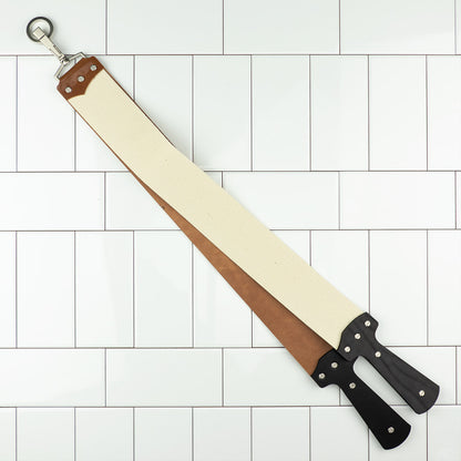 Ezra Arthur Cordovan strop with leather and canvas belts, ideal for honing razors, hangs against a tile backdrop.