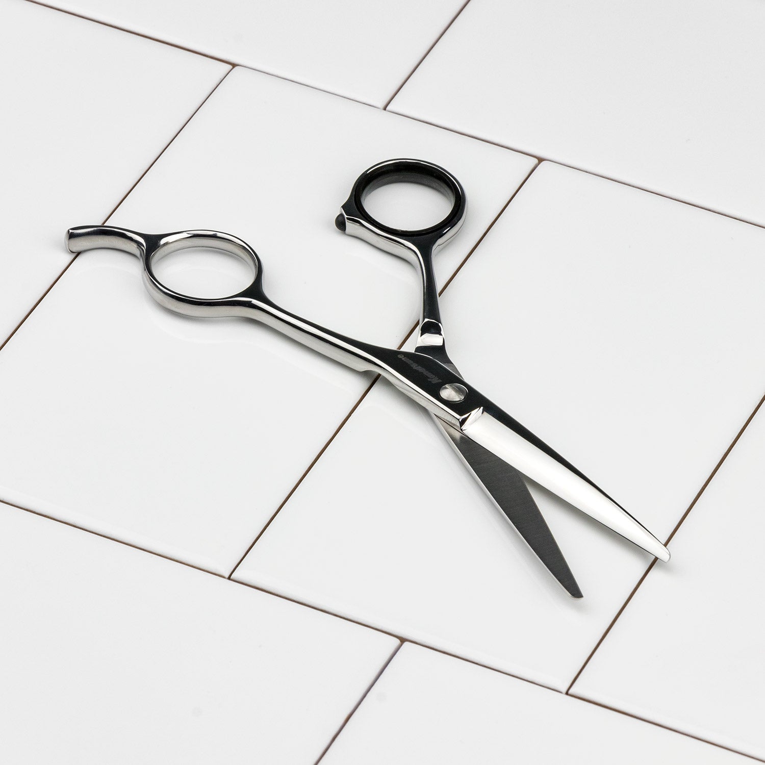 Seki Kanetsune Pro Hair Scissors, crafted from AUS-8 steel, rest on white tiles, showcasing their precision and comfort, ideal for barbers and home use.
