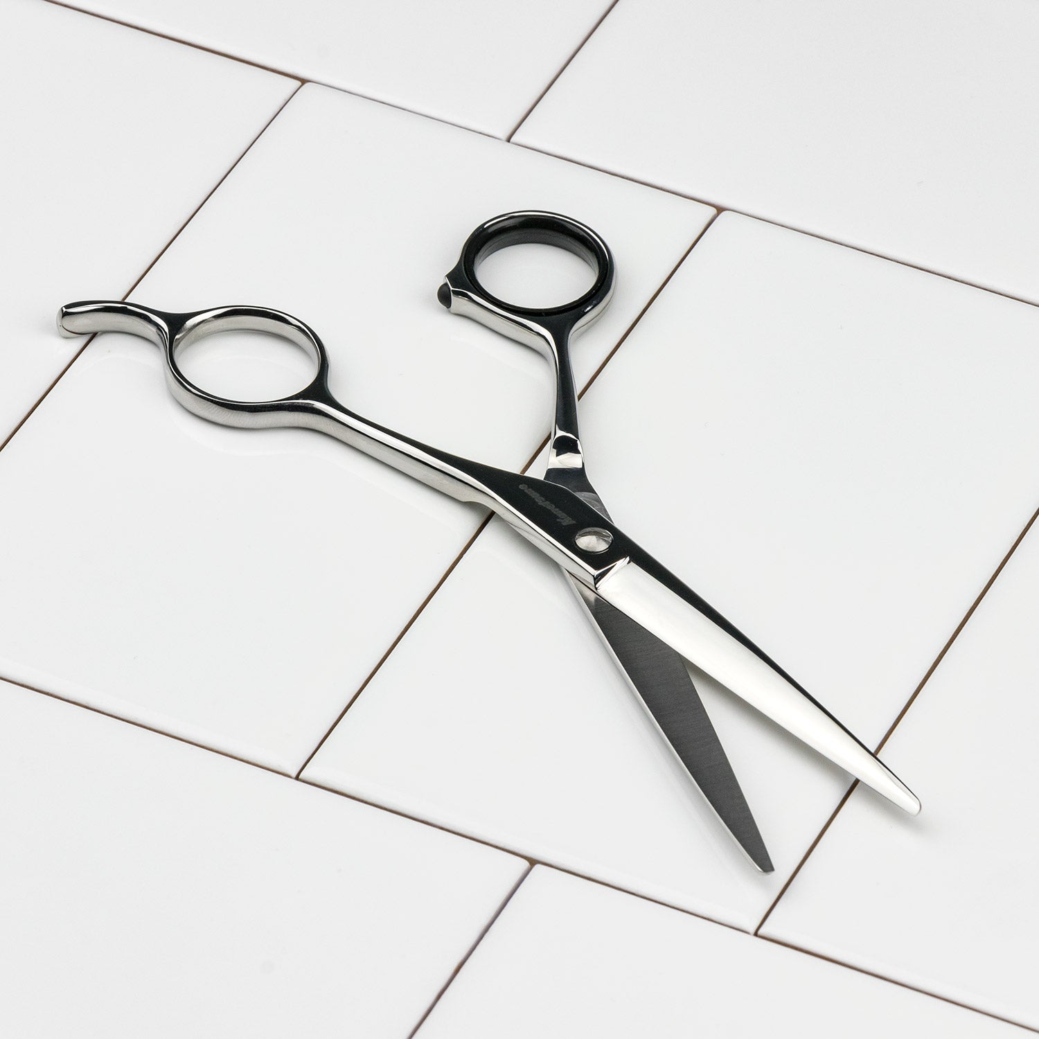 Seki Kanetsune Pro Hair Scissors made of AUS-8 steel, lying open on a white tiled surface, showcasing precision craftsmanship ideal for professional or home use.