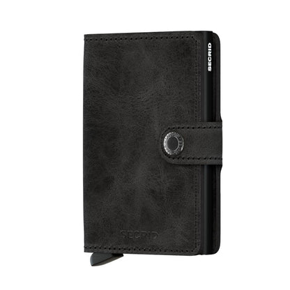 Secrid Wallets Miniwallet - Vintage featuring a compact leather design with a snap-button strap and integrated metal Cardprotector lever for easy access. RFID-blocking, handcrafted in Holland.