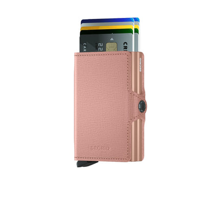 Secrid Wallets Twinwallet, a compact rose-pink card wallet with RFID protection, showcases a lever mechanism fanning out cards for easy access. Made in Holland.