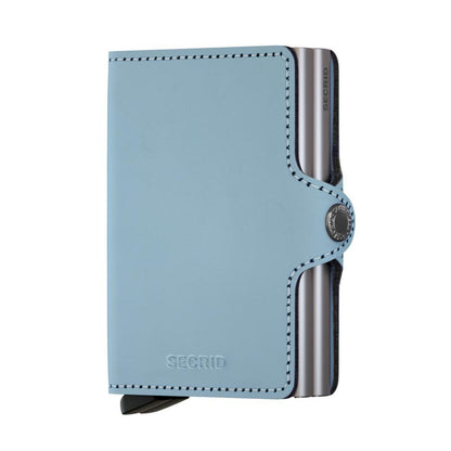 Secrid Wallets Twinwallet, a slim, pastel-blue leather cardholder with RFID protection, features a lever for easy card access, holding 2-6 cards.
