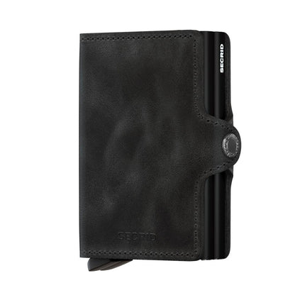 Secrid Wallets Twinwallet: Black leather wallet featuring a snap-closure, metal card-protector, and stitched exterior, accommodating 10-12 cards, cash, and more, with RFID blocking.