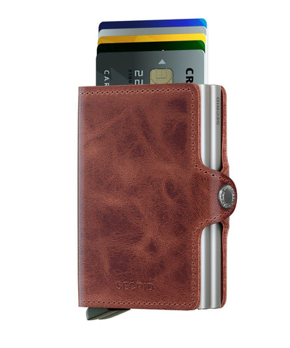 Secrid Wallets Twinwallet showcases a compact leather design with a metal card mechanism, holding 10-12 cards, cash, and business essentials, featuring RFID protection.